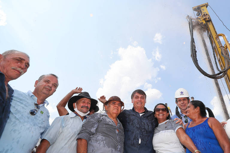 Bolsonaro, acompanhado de moradores da comunidade, que se molham nas águas do poço artesiano da Comunidade de Angélica, em Ipanguaçu (RN)