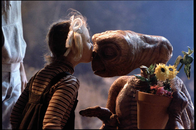 A atriz Drew Barrymore beija o E.T. no rosto