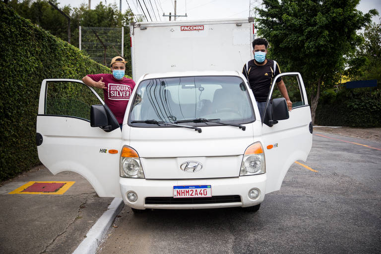 Luan Cardoso, 21 (esq) e Vando de Souza da cruz, 26, no ponto de distribuição das mercadorias, em São Paulo