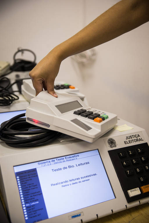 Servidores da Justiça Eleitoral ajustam urnas na primeira zona eleitoral, na Bela Vista, em São Paulo