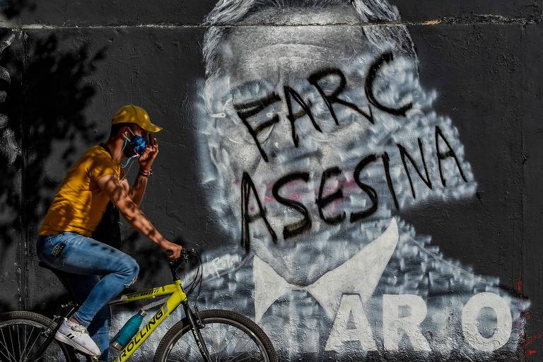 Pichação 'Farc assassina' em muro de Bogotá cobre grafite que retrata o ex-presidente colombiano Álvaro Uribe 