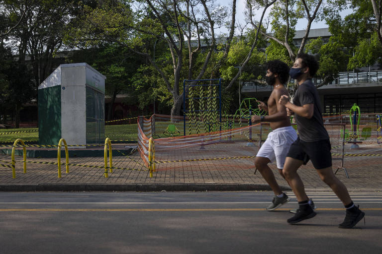 Paulistanos correm de máscara no parque Ibirapuera (zona sul) em frente a academia urbana interditada por causa do novo coronavírus