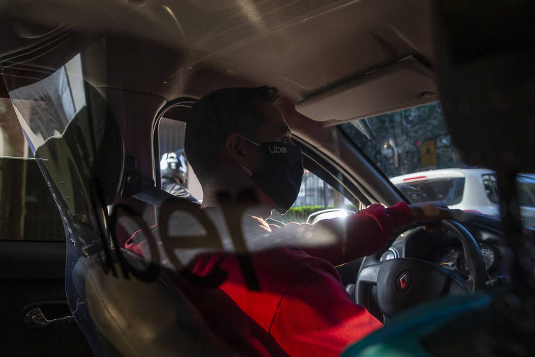 Em carro de aplicativo, proteção acrílica isola o motorista dos passageiros