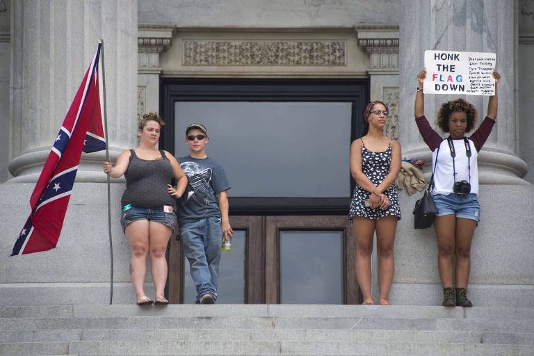 Manifestantes a favor dos símbolos confederados ao lado de ativistas contra o uso da bandeira em frente à Câmara da Carolina do Norte, em Columbia