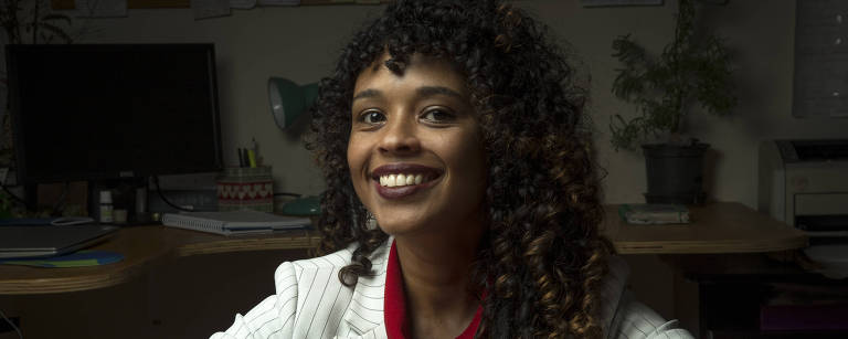 A advogada Haydée Paixão Soula sorri com os braços apoiados sobre a mesa