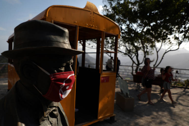 Uma estátua usa máscara facial no Morro do Pão de Açúcar, uma das principais atrações turísticas do Rio de Janeiro