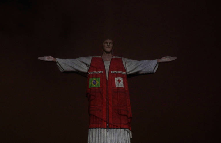 Um colete de voluntário da Cruz Vermelha foi projetado na estátua do Cristo Redentor em homenagem à assistência aos brasileiros durante o a pandemia do novo coronavírus