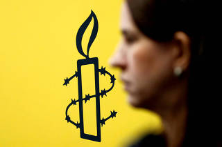 FILE PHOTO: The logo of Amnesty International is seen next to director of Mujeres En Linea Luisa Kislinger, during a news conference in Caracas