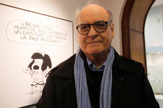 FILE PHOTO: Argentine cartoonist Quino poses in front of his most famous comic character Mafalda during the opening ceremony of the exhibition of his works at the Museo del Humor in Buenos Aires