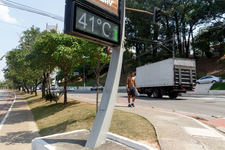 caminhão passa em rua ao lado de termômetro que marca 41 graus