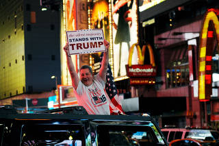 A man leans out of a Hummer shouting words in support of U.S. Republican presidential nominee Donald Trump while driving through Times Square in New York