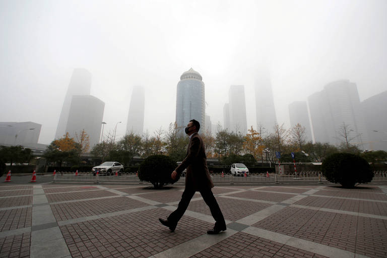 Homem usa máscara para evitar "smog" (nuvem tóxica) no distrito comercial de Pequim, em 2018