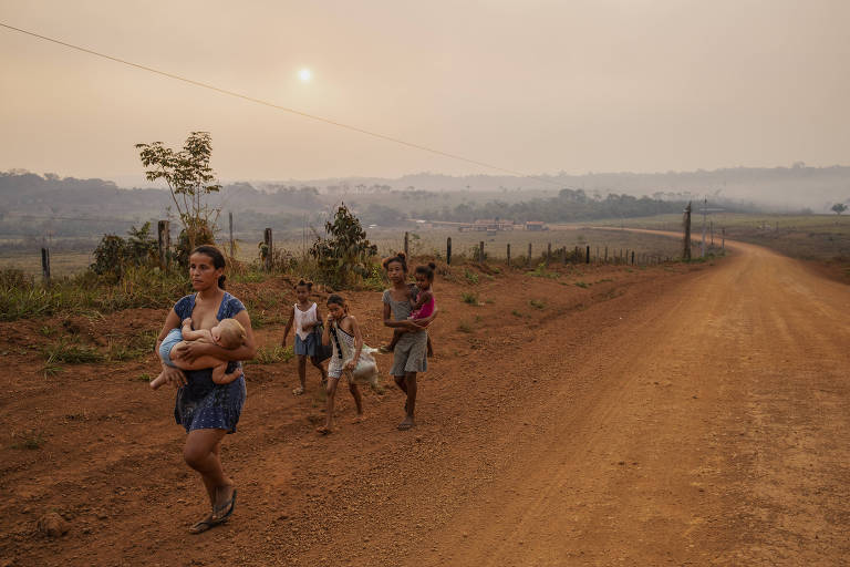 Família recém-chegada de Rondônia caminha pela rodovia Transamazônica, na zona rural de Apuí, no sul do Amazonas