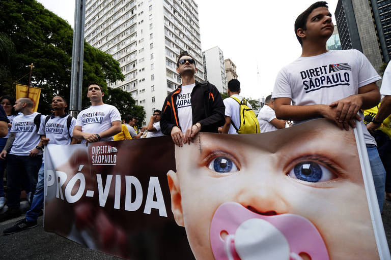 Em manifestação da avenida Paulista, homens carregam uma faixa com a foto de um bebê e a frase "pró-vida"