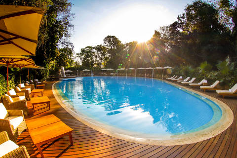 Piscina no Sítio do Carroção, com espreguiçadeiras e mesas para refeições 