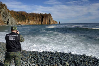 A member of Russian Investigative Committee works on the shore of Avacha Bay following the recent discovery of high pollution levels off the coast of Kamchatka Peninsula