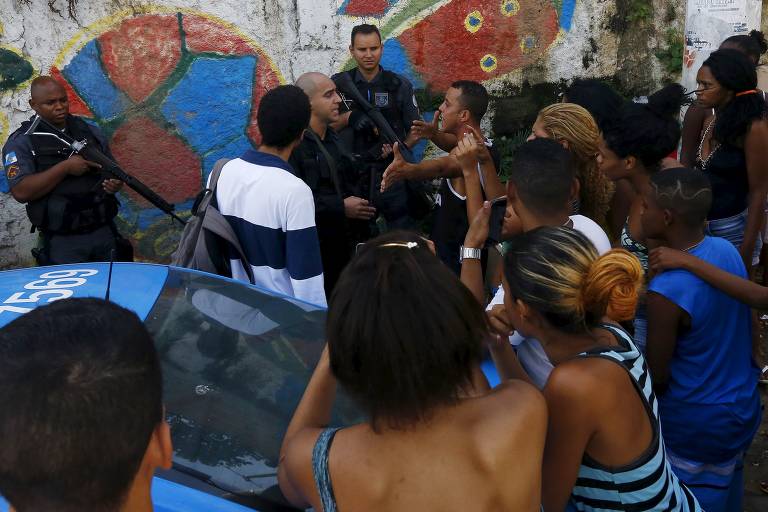 Moradores protestam contra policiais próximo da área onde dois homens foram encontrados mortos no conjunto de favelas do São Carlos, no Rio, em 2015