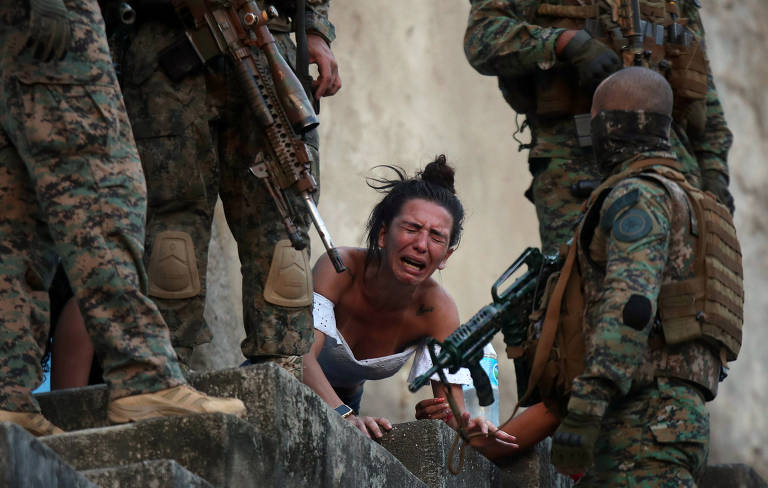 Operações não pararam após a decisão do STF, com comunicação ao Ministério Público. Na foto, mulher chora ao lado de corpo de uma pessoa baleada no complexo de São Carlos, durante uma incursão policial que terminou em forte confronto com traficantes 