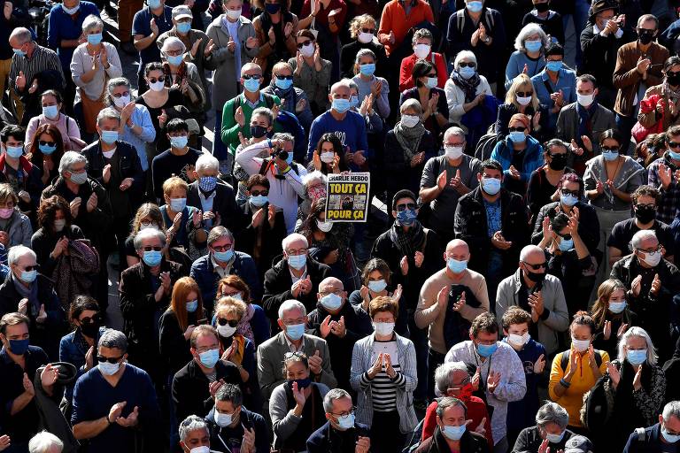 Manifestante ergue exemplar do jornal satírico Charlie Hebdo durante protesto em Toulouse