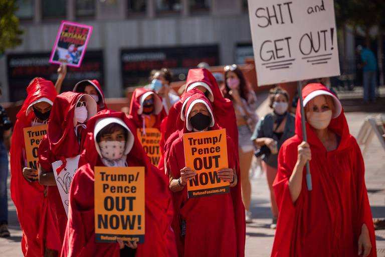 Com roupas em referência ao livro 'O Conto da Aia', manifestantes protestam na Marcha das Mulheres em Los Angeles