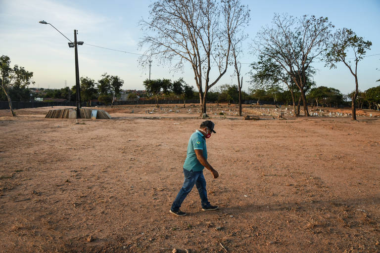 José Valdir da Silva, 59, o administrador do cemitério Parque Bom Jardim, caminha sob 2000 corpos enterrados e ainda sem lápides