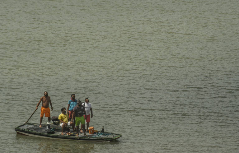 Cinco homens dividem pouco espaço em pequena embarcação no mar da praia de Mucuripe, em Fortaleza (CE)
