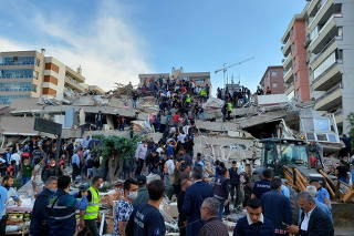 Locals and officials search for survivers at a collapsed building in Izmir