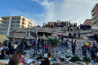 Locals and officials search for survivers at a collapsed building in Izmir