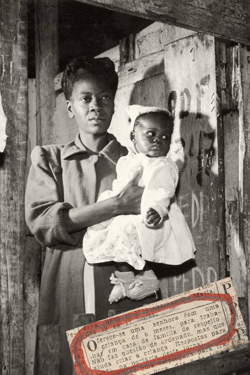 Uma mãe segura seu filho numa habitação feita de madeira, numa favela carioca , em 1950