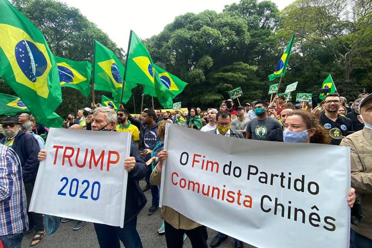 Apoiadores de Bolsonaro com cartazes pedindo "fim do Partido Comunista Chinês" e "Trump 2020"