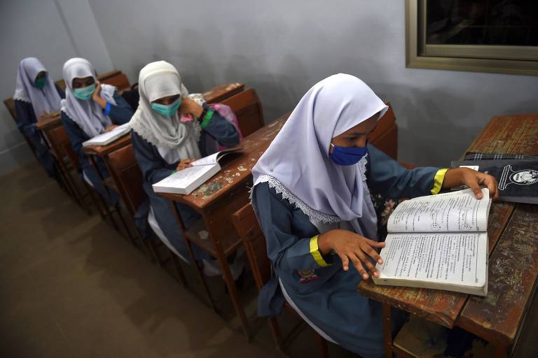 Estudantes usam máscaras durante aula em uma escola em Karachi, Paquistão