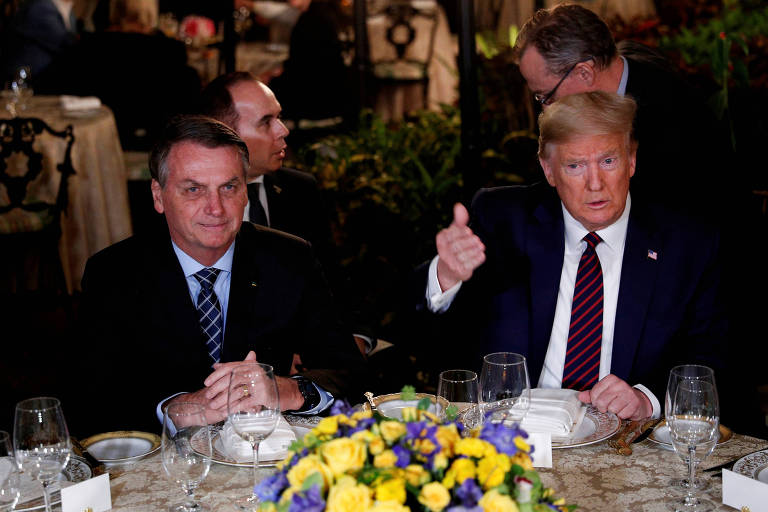 Bolsonaro e Trump diante de uma mesa de jantar