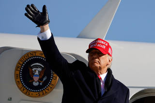 FILE PHOTO: U.S. President Donald Trump gestures as he leaves after holding a campaign rally at Fayetteville Regional Airport in Fayetteville
