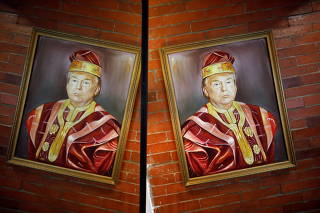 A painted portrait of U.S President Donald Trump wearing a gold-trimmed red agbada, a traditional flowing robe worn by Yoruba men in southern Nigeria, hangs in a upscale restaurant in Lagos