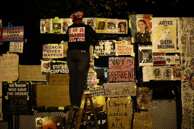 Manifestante coloca placas na praça Black Lives Matter em Washington D.C. na segunda-feira (2), véspera das eleições dos EUA