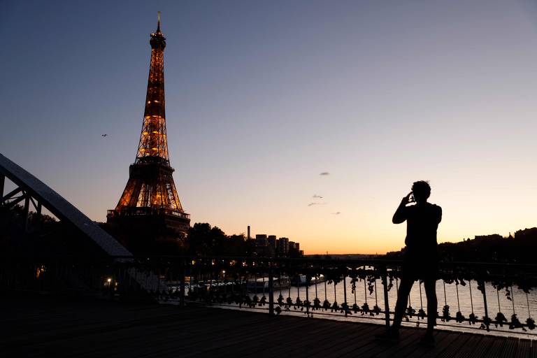 Uma pessoa fotografa a Torre Eiffel, em Paris, em 4 de novembro de 2020, durante lockdown na França