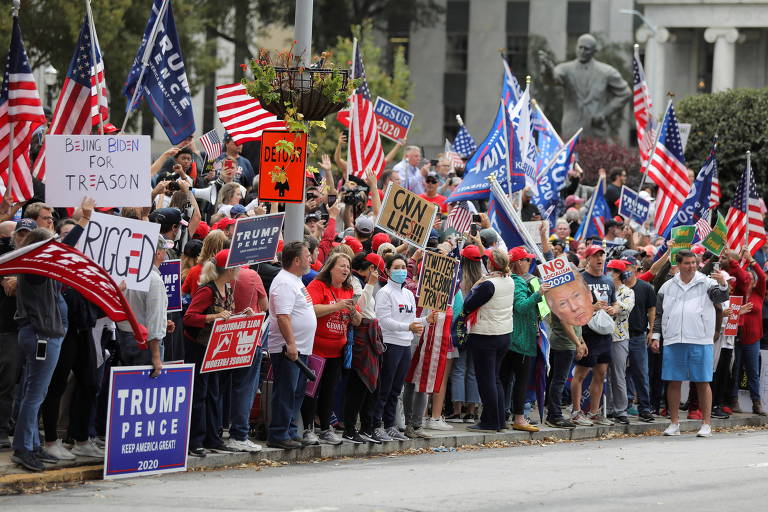 Manifestantes caregam cartazes contra a mídia e alegando fraudes na contagem de votos em ato em favor de Trump em Atlanta (Geórgia)