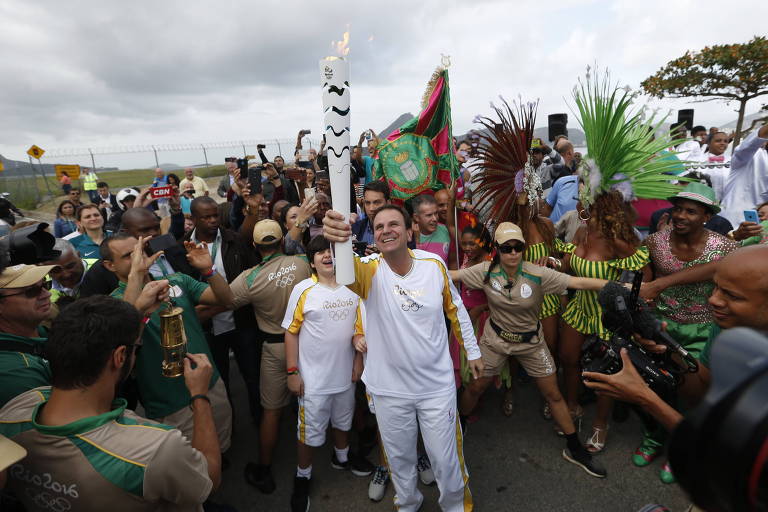 O então prefeito Eduardo Paes recebe a tocha olímpica no Rio de Janeiro, em 2016