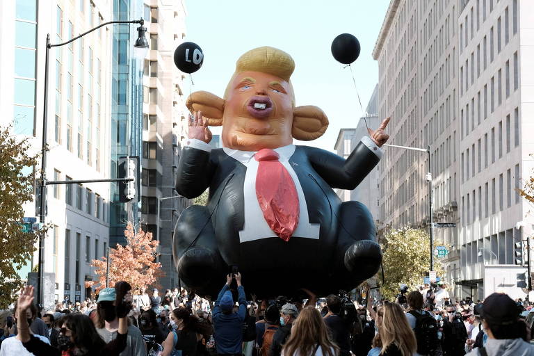Pessoas carregam balão com forma do presidente Donald Trump, em Washington, em comemoração da vitória de Joe Biden 