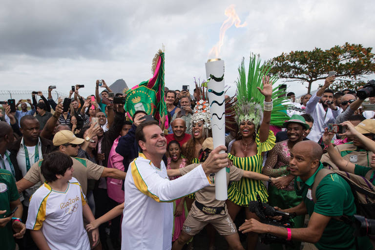 Eduardo Paes foi o responsável pela preparação da cidade para sediar as Olimpíadas de 2016; na foto, ele recebe a Tocha Olímpica na Escola Naval e inicia o trajeto do revezamento do fogo olímpico pela cidade.