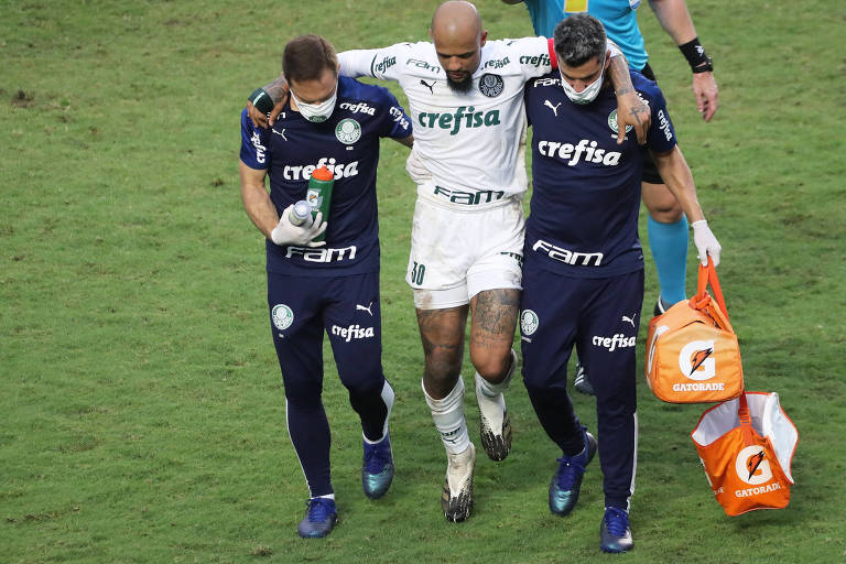 Felipe Melo é amparado por membros da comissão técnica do Palmeiras para deixar o campo após sofrer uma lesão