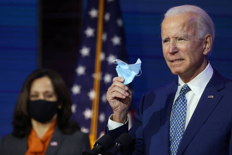 O presidente eleito dos EUA, Joe Biden, segura máscara durante pronunciamento ao lado da vice-presidente eleita, Kamala Harris, em Wilmington, em Delaware