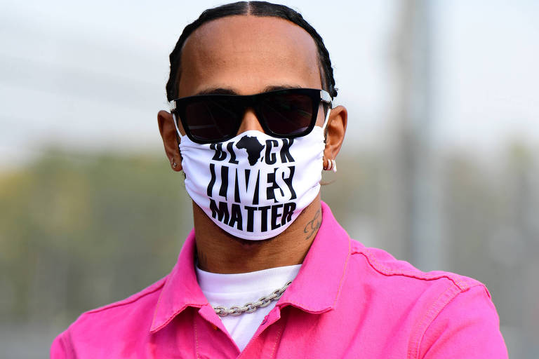 Lewis Hamilton com camisa rosa, óculos escuro e uma máscara do movimento "Black Lives Matter"