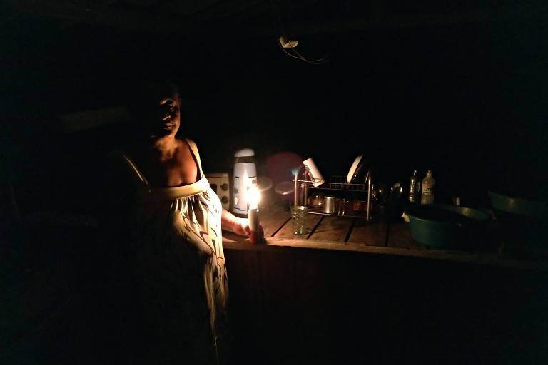 No escuro, Doralice Jesus Picanço, 63, do quilombo Conceição, acende uma lamparina improvisada num frasco de desodorante