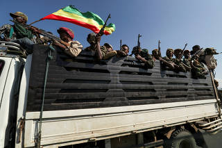 FILE PHOTO: Members of Amhara region militias ride on their truck as they head to face the Tigray People's Liberation Front in Sanja