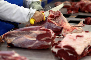 FILE PHOTO: A worker cuts up joints of beef at the Marfrig Group slaughterhouse