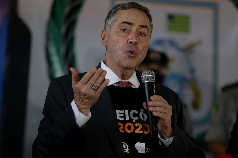 barroso discursa ao microfone vestindo camisa com letreiro laranja "eleições 2020"