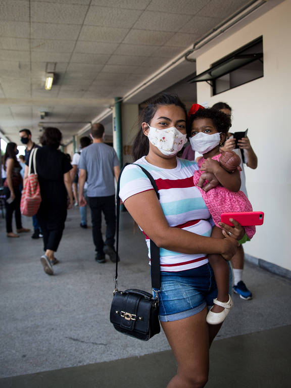 A eleitora Milleny Ambar, 24 aguarda sua vez de votar com sua filha, na PUC, no bairro de  Perdizes, em São Paulo