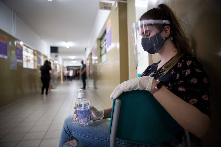 Mesária aguarda eleitores em frente a seção, no Colégio Salesiano, no bairro de Santana, na zona norte de São Paulo