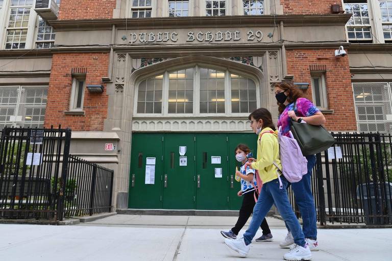 Estudantes caminham em frente a escola pública no Brooklyn. Aulas presenciais estarão suspensas a partir de quinta-feira (19)